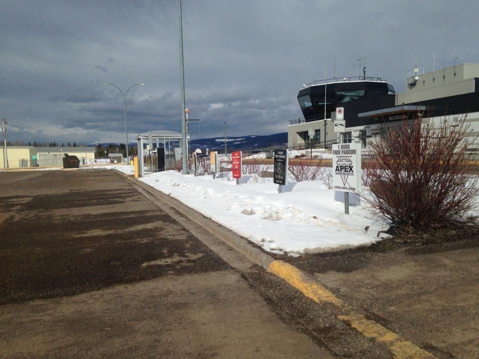 An airport parking stall with snow on the curb